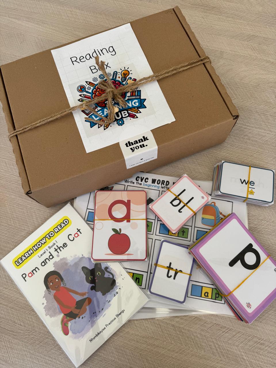 Reading Box contents including alphabet cards, CVC word cards, blending cards, phonics materials, and a Level 1 reading book